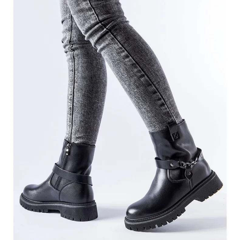 Bottes isolées noires avec une chaîne de Smithsons le noir