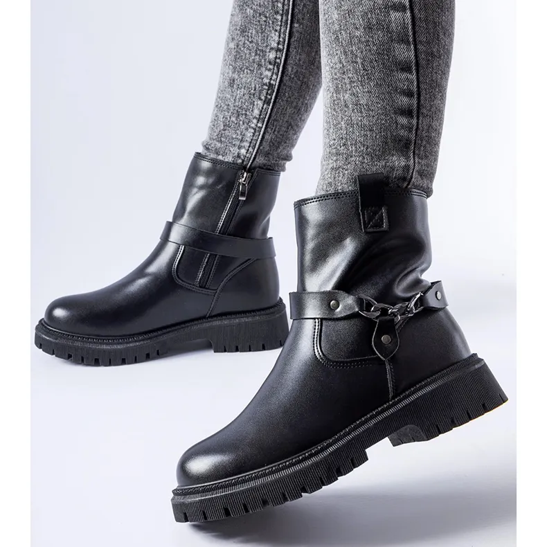 Bottes isolées noires avec une chaîne de Smithsons le noir